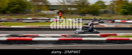 Un'immagine panoramica di un kart da corsa mentre si guida su una pista. Foto Stock