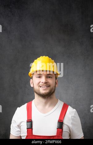 Felice, sorridente lavoratore con casco giallo Foto Stock