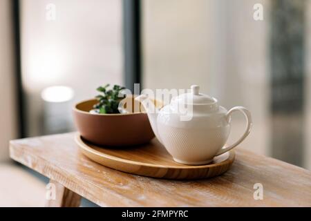 Utensili da cucina, come bollitore, caffettiera, su un vassoio di legno prima colazione. Messa a fuoco selettiva morbida. Foto Stock