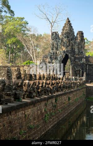 Fila di asuras (demoni) e South Gate, Angkor Thom, il Parco Archeologico di Angkor, Siem Reap, Cambogia Foto Stock