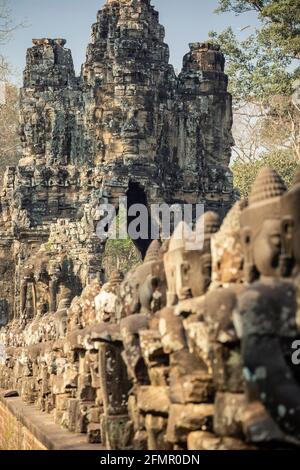 Fila di divinità e la porta sud, Angkor Thom, il Parco Archeologico di Angkor, Siem Reap, Cambogia Foto Stock