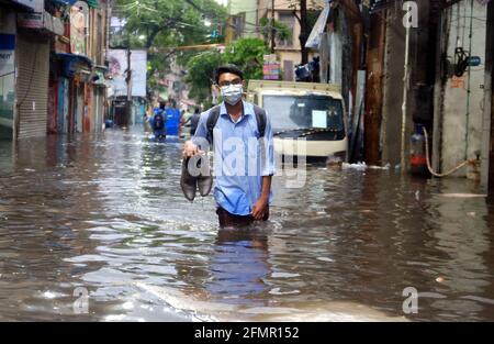 Kolkata, India. 11 Maggio 2021. Un uomo percorre l'acqua dopo una pioggia pesante a Kolkata, in India, il 11 maggio 2021. Credit: Sr/Xinhua/Alamy Live News Foto Stock