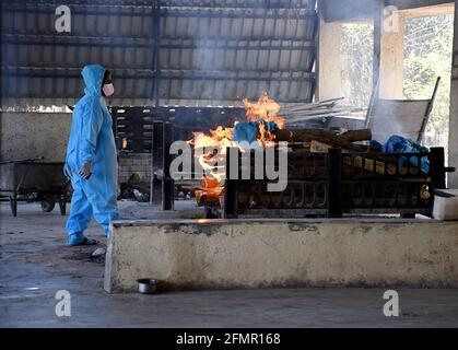 Mumbai, India. 11 Maggio 2021. Lavoratore comunale vestito in una suite di dispositivi di protezione individuale (PPE) cremati un corpo di una persona che è morto a causa della malattia di corona virus a Mumbai. Il tasso di mortalità è aumentato nella seconda ondata a causa della diffusione rapida dell'infezione da una persona all'altra. Credit: SOPA Images Limited/Alamy Live News Foto Stock