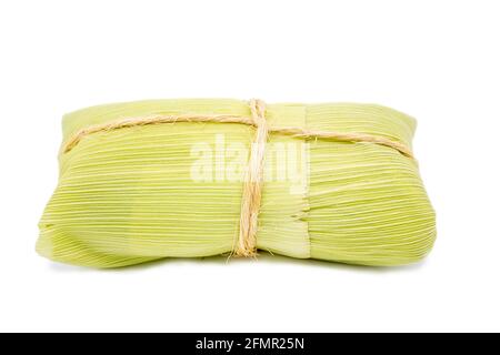 Pamonha brasiliano su sfondo bianco, dessert tipico delle città rurali del Brasile. Mais dolce con formaggio servito nella paglia Foto Stock