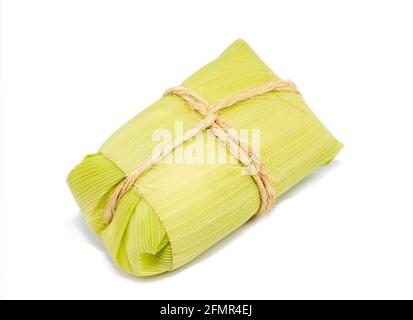 Pamonha brasiliano su sfondo bianco, dessert tipico delle città rurali del Brasile. Mais dolce con formaggio servito nella paglia Foto Stock