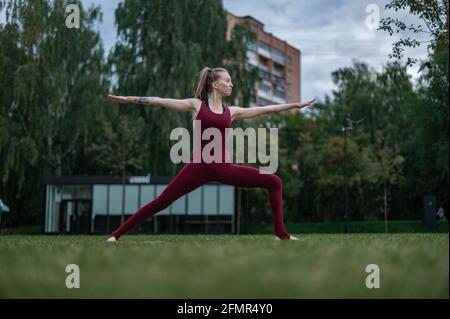 La ragazza pratica yoga e meditazione in città. Foto Stock