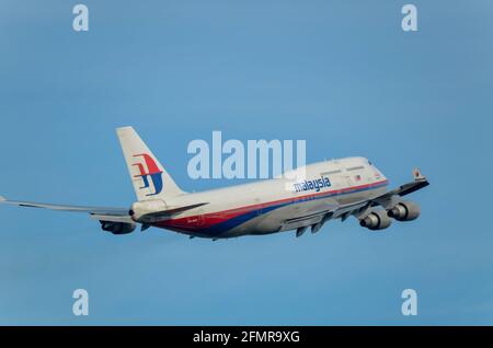 Malaysia Airlines Boeing 747 aereo di linea Jumbo Jet 9M-MPK che si allontana dopo il decollo dall'aeroporto Heathrow di Londra, Regno Unito. Uscire nel cielo blu Foto Stock