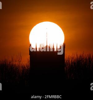 Silhouette del Christchurch Priory al tramonto con il sole dietro. Christchurch Regno Unito Foto Stock