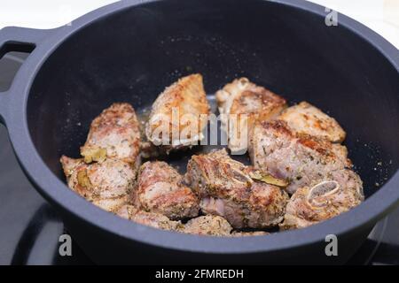 Carne cucinata in una pentola nera. Concetto di cucina. Foto Stock