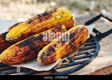 Mais grigliato sulla pannocchia con verdure. Foto Stock