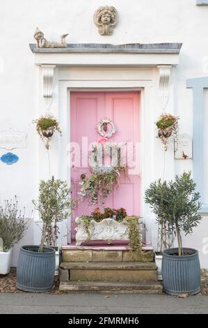 BUCKINGHAMSHIRE, Regno Unito - 25 dicembre 2020. Porta d'ingresso rosa ornato di casa d'epoca decorata con un ghirlanda di Natale. Inghilterra, Regno Unito Foto Stock