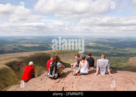 BRECON BEACON, REGNO UNITO - 25 APRILE 2011. Gruppo misto di giovani caucasici, escursionisti seduti sul picco di Pen Y Fan, Brecon Beacons, Galles, Regno Unito Foto Stock