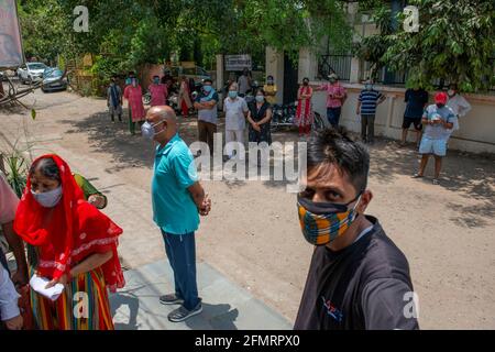 Ghaziabad, India. 11 Maggio 2021. La gente attende sotto l'ombra fuori da un centro di vaccinazione, dopo il permesso del governo di Utttar Pradesh di vaccinare persone di età superiore a 18 anni. Credit: SOPA Images Limited/Alamy Live News Foto Stock