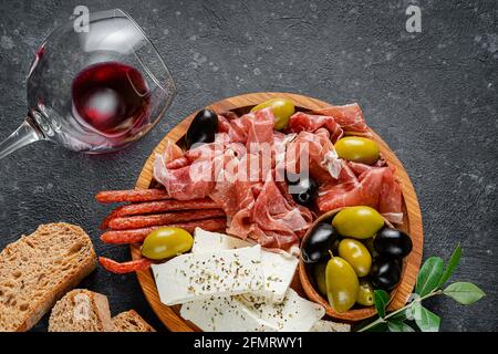 Piatto con antipasti a fette di carne, formaggio e olive. Vista dall'alto, disposizione piatta. Foto Stock