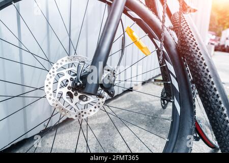 Dettaglio primo piano bicicletta in fibra di carbonio nera smontata con ruota rimossa e pneumatico dopo foratura o incidente durante la riparazione in officina stazione all'aperto Foto Stock