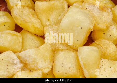 Pezzi di patate fritte con olio, pepe aneto e sale. Piatto con patata tipica spagnola bravas. Foto Stock