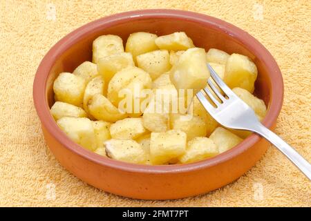 Pezzi di patate fritte con olio, pepe aneto e sale. Piatto con patata tipica spagnola bravas. Foto Stock