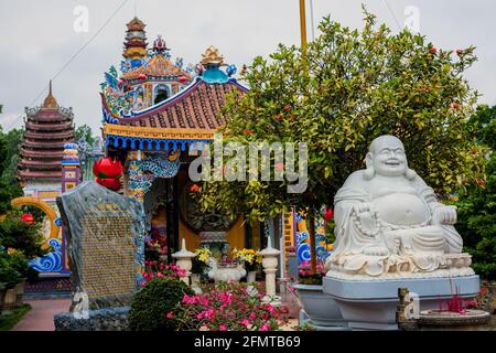 Sorridendo grande statua di buddha al tempio cinese garish - Long Tuyen Tu a Hoi An, Vietnam Foto Stock