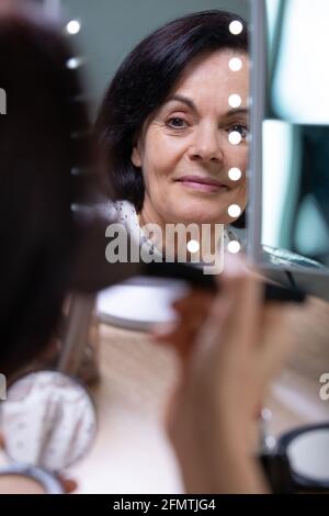 Ritratto di bella donna matura di applicare il make up Foto Stock