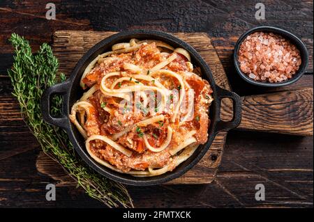 Pasta Feta al forno alla moda con pomodori arrostiti al forno e formaggio in padella. Sfondo di legno scuro. Vista dall'alto Foto Stock