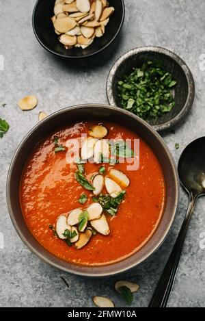 Testa di peperone rosso e zuppa di pomodoro con basilico e. fettine di mandorle Foto Stock