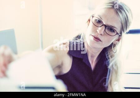 Una giovane donna che lavora in un ufficio. Foto Stock