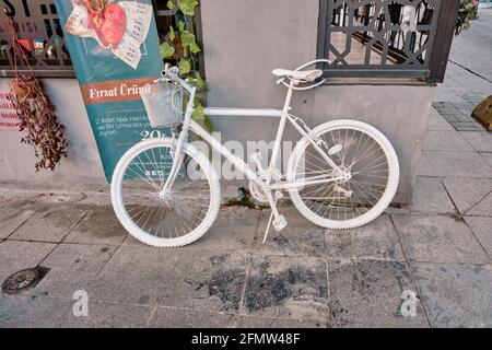 Bicicletta e bicicletta di tipo montano di colore bianco di fronte al grazioso caffè di moda, Kadikoy istanbul di mattina presto. Foto Stock