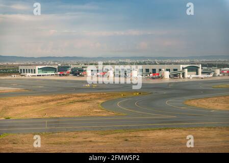 Aeroporto di Paphos a Cipro. Aerei sulla pista e presso gli hangar. La Taxiway per i terminal dell'aeroporto. Un aereo in molti aeroporti. Foto Stock