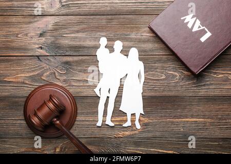 Figure di famiglia con il gavel del giudice e il libro di legge sopra sfondo di legno Foto Stock