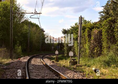 Binari ferroviari accanto all'attraversamento ferroviario di una città italiana Foto Stock