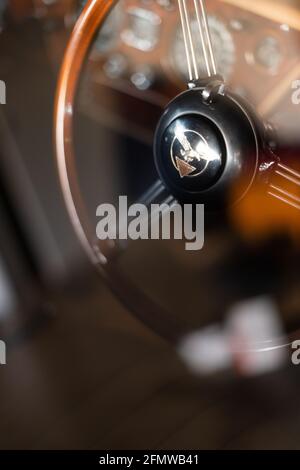 Volante in legno lucido e cruscotto sfocato attraverso la finestra dell'auto con riflessi all'interno della Alvis Classic Car, Nuova Zelanda, d'epoca degli anni '60 Foto Stock