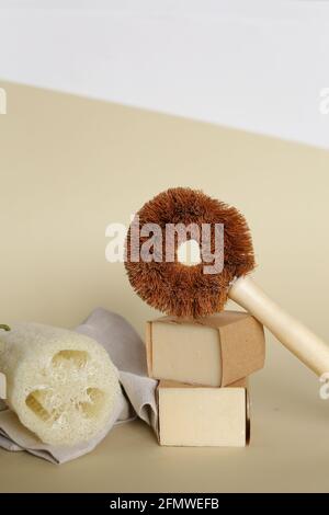 Concetto di accessori per il bagno. Spugna beige naturale Luffa cylindricaon con detergente ecologico per toilette su fondo beige neutro. Zero sprechi, eco-compatibile Foto Stock