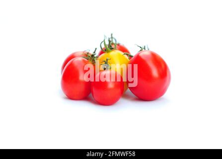 Pomodori biologici. Pomodori prugne rossi e gialli, impastare i pomodori su fondo bianco. Foto Stock