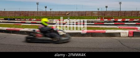 Un'immagine panoramica di un kart da corsa mentre si guida su una pista. Foto Stock