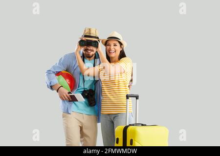 Felice coppia sorridente innamorata di valigia e accessori da spiaggia scatto in studio Foto Stock