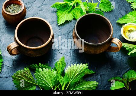 Tazze di creta con ortica tea. Medicina di erbe, omeopatia Foto Stock