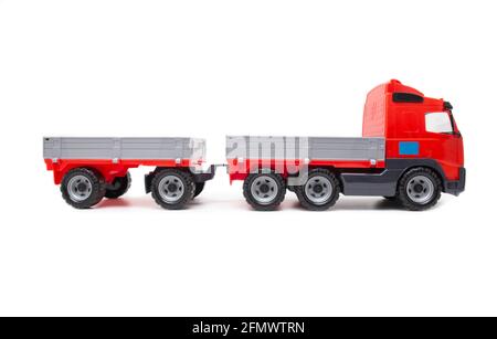 Giocattolo rosso per bambini, camion con rimorchio su sfondo bianco, isolamento, trasporto Foto Stock