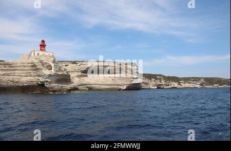 Piccolo Faro Rosso sopra la scogliera a strapiombo vicino alla città Di Bonifacio sull'isola francese chiamata Corsica nel Mar Mediterraneo Foto Stock