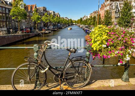 Amsterdam, Paesi Bassi - 18 settembre 2020. Vecchia bici olandese contro la ringhiera di un ponte su un canale in una giornata di sole ad Amsterdam, Olanda. Foto Stock