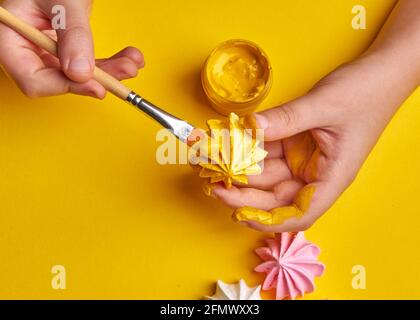 meringa bianca con vernice gialla su sfondo giallo Foto Stock