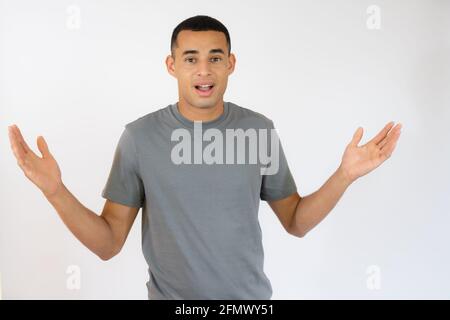 Un giovane sorpreso in una t-shirt casual isolata su sfondo bianco. Foto Stock