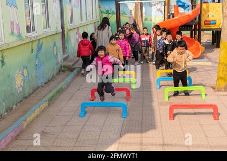 Studenti di asilo che giocano una scuola rurale a Qufu, Shandong, Cina. Foto Stock