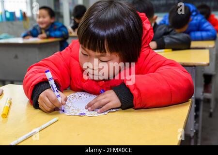 Gli studenti primari di una scuola rurale di Xiuning, Anhui, Cina che fanno opere d'arte. Foto Stock