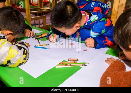 Gli studenti primari di una scuola rurale di Xiuning, Anhui, Cina che fanno opere d'arte. Foto Stock