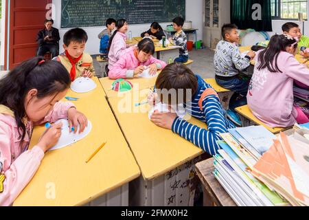 Gli studenti primari di una scuola rurale di Xiuning, Anhui, Cina che fanno opere d'arte. Foto Stock