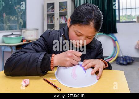 Gli studenti primari di una scuola rurale di Xiuning, Anhui, Cina che fanno opere d'arte. Foto Stock