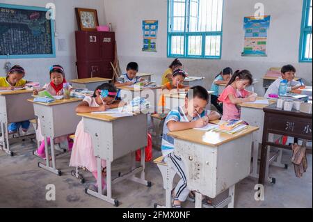Studenti che svolgono vari lavori in classe di una scuola rurale ad Anhui, in Cina Foto Stock