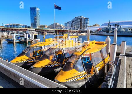 Taxi d'acqua gialla ormeggiati da un molo a Darling Harbour, Sydney, Australia Foto Stock