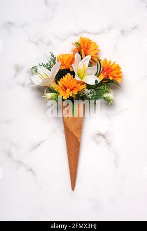 cono gelato con fiori su un tavolo in marmo Foto Stock
