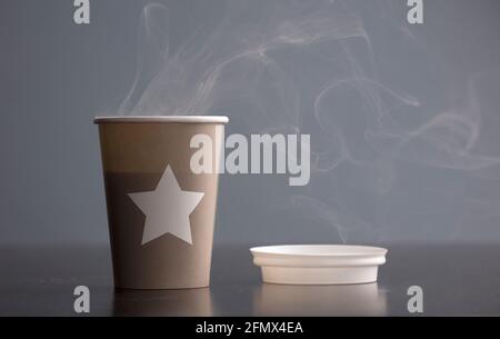 Bicchiere di caffè caldo, con fumo, sul tavolo, sfondo verde Foto Stock